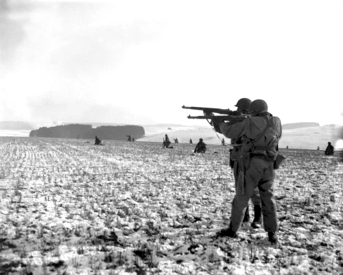 Soldados de infantería estadounidenses disparan contra posiciones alemanas durante el avance para liberar Bastogne, diciembre de 1944