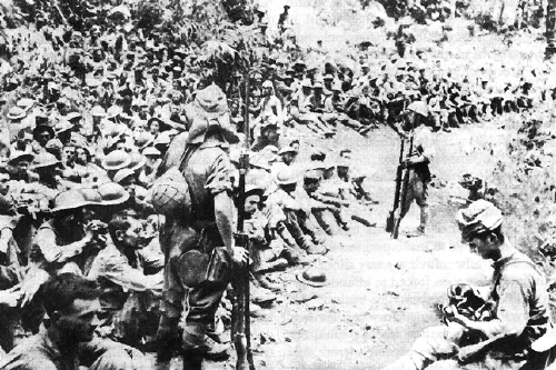 Soldados japoneses custodian a prisioneros estadounidenses y filipinos tras la rendición de Bataan en 1942