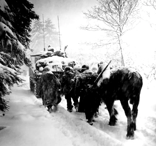 Tropas de la 82.ª División Aerotransportada avanzan bajo una tormenta de nieve junto a un tanque durante la batalla de las Ardenas, enero de 1945
