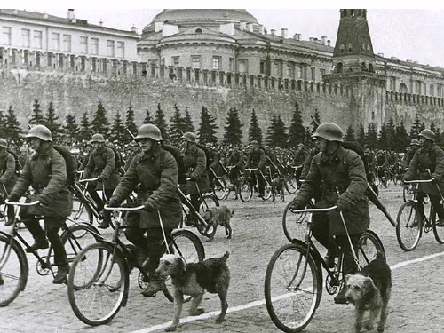 Soldados soviéticos con perros militares en bicicleta durante un desfile en la Plaza Roja de Moscú en 1938
