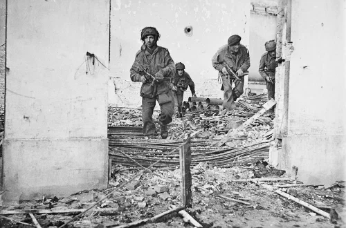 Paracaidistas británicos avanzando entre casas dañadas en Oosterbeek durante la operación Market Garden
