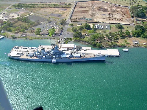 Vista del memorial de Pearl Harbor con un acorazado en el puerto de Honolulu